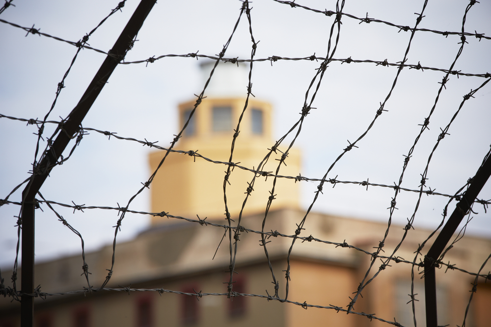photogaph of barbed wire around prison building