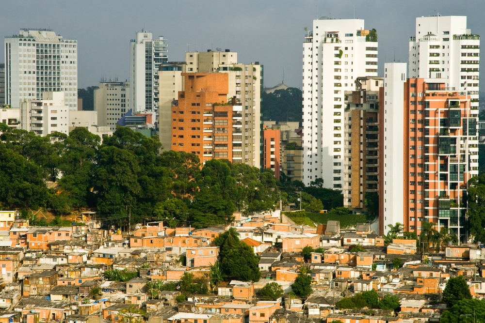 photograph of Sao Paulo favelabutting up against expensive buildings in background