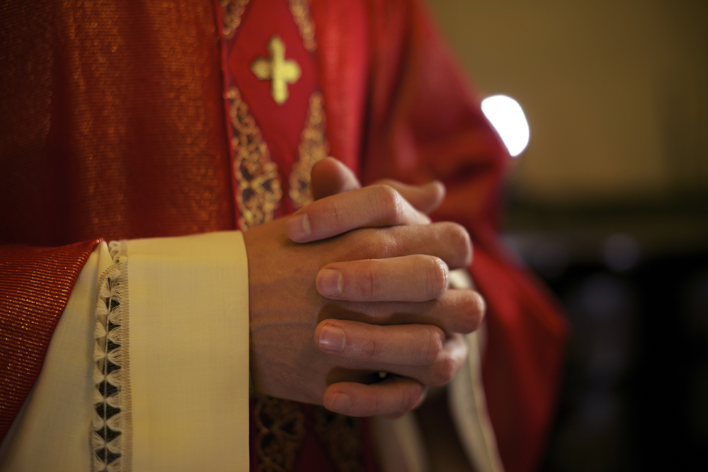 close-up photograph of catholic priests folded hands