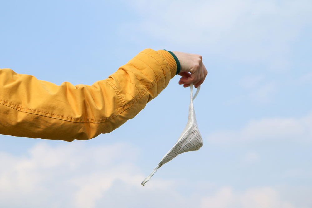 photograph of someone casting off face mask