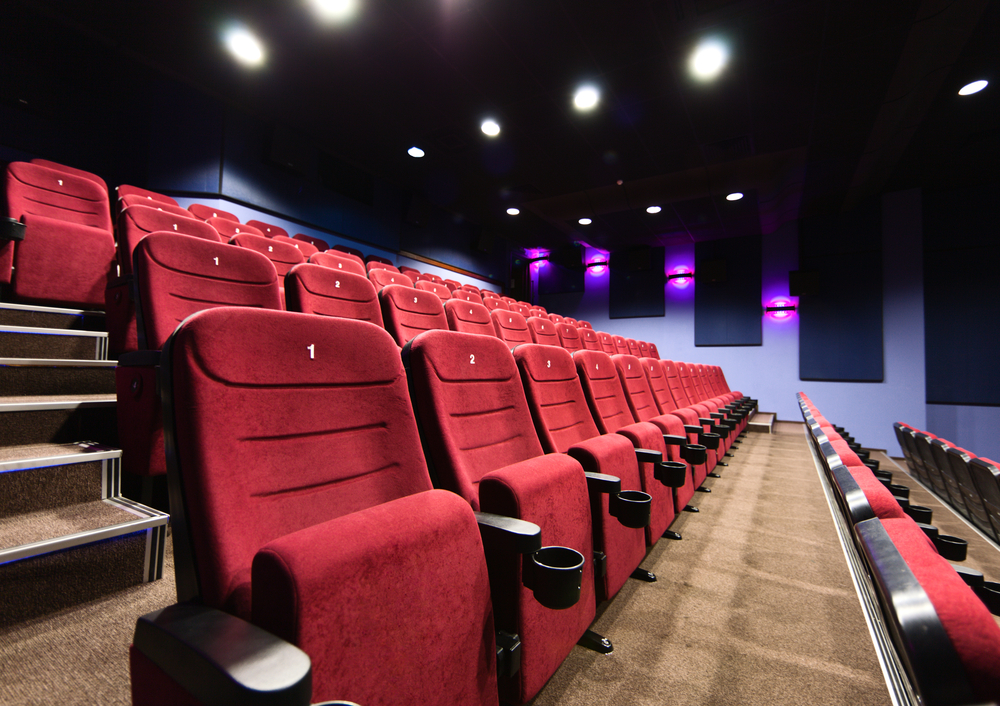 photograph of empty movie theater with lights up