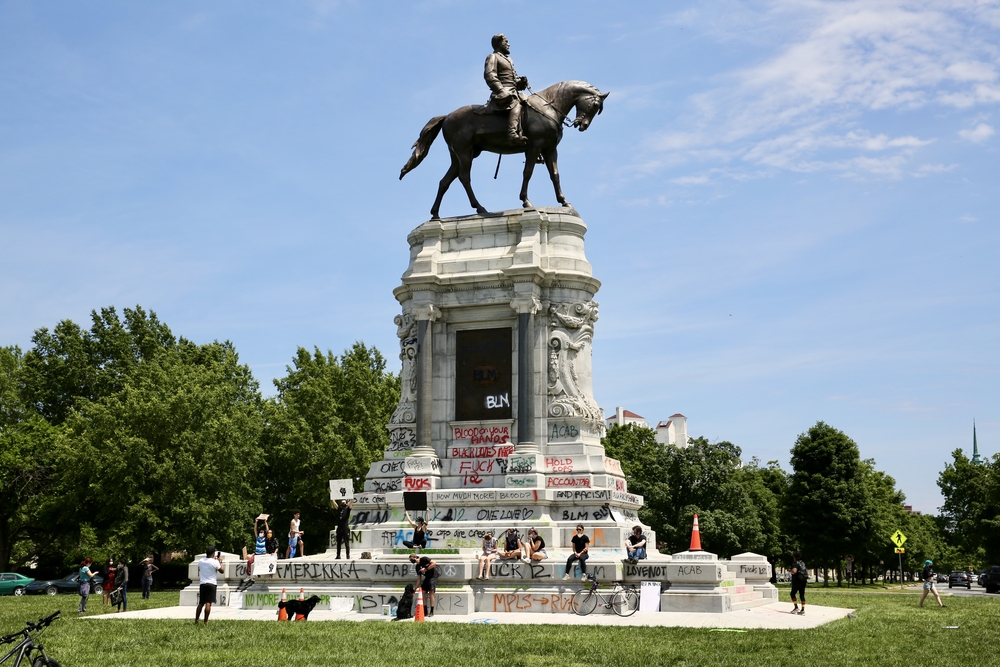 Statue of confederate general Robert E Lee with spray painted writing on plinth