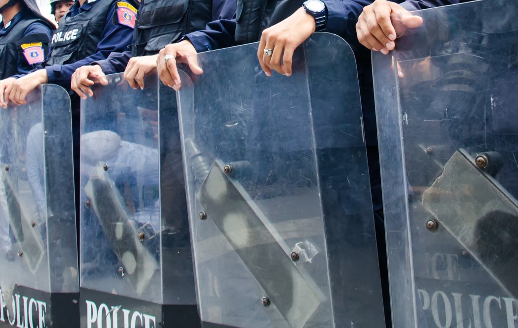 photograph of police line with riot shields