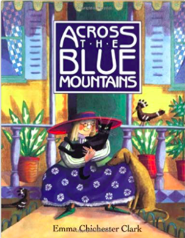 An illustrated picture book cover for Across the Blue Mountains featuring a blond woman in a large pink hat cuddling with a black cat as she sits in the doorway of her colorful house.