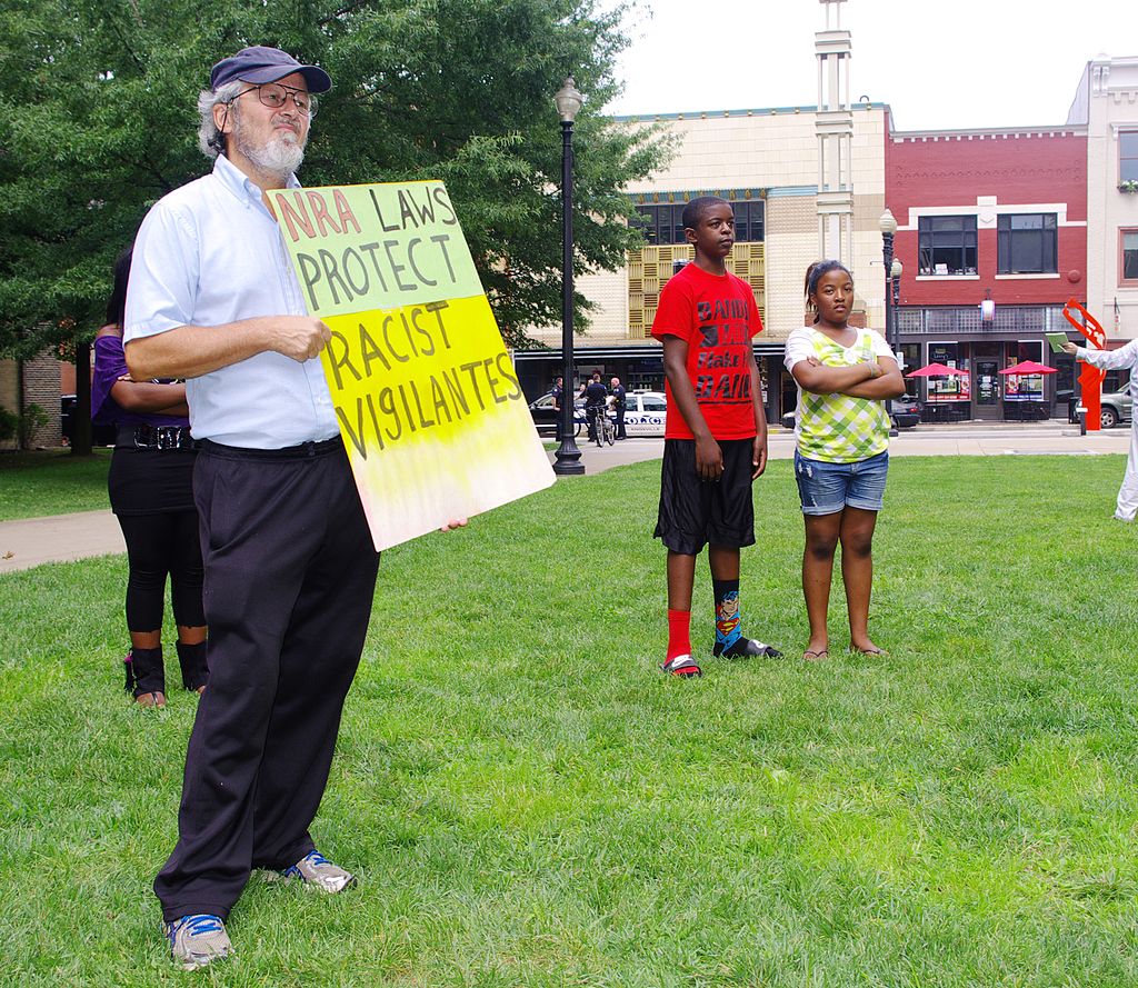 A protester displays a sign at the "Justice for Trayvon Martin Rally" at Krutch Park in Knoxville, Tennessee, United States. The sign reads, "NRA laws protect racist vigilantes."
