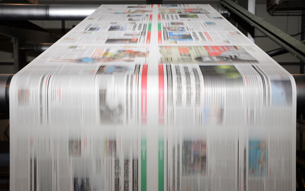 photograph of newspaper printing press in operation