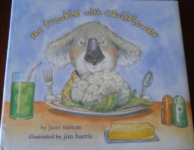 Cover image for The Trouble with Cauliflower featuring a painting of a koala seated at a table with a plate of cauliflower in front of it. There's a glass and a stick of butter on the table as well