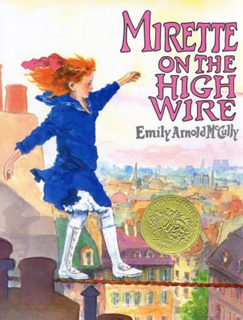 Cover image for Mirette on the High Wire with an illustration of a young white girl with bright red hair and a blue sailor dress balancing on a wire high above the rooftops of a townscape.