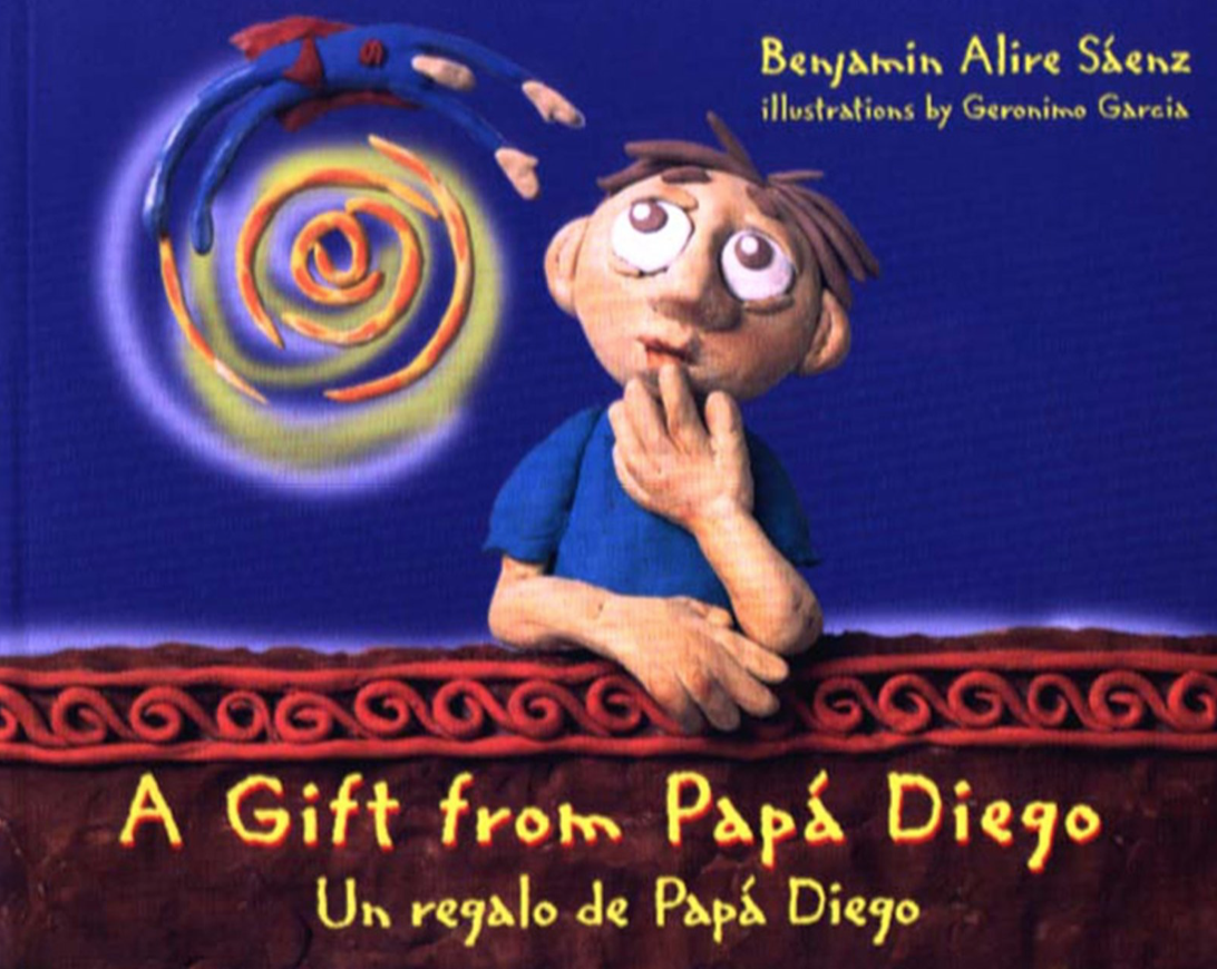 Cover image for A Gift from Papá Diego featuring an illustration modeled from clay. There is a little boy with brown eyes and brown hair wearing a blue shirt and leaning on a ledge. He is looking up and has his hand at his mouth in an expression of wonder. There is a giant colorful spiral in the sky above his head.