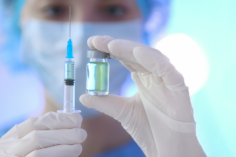 photograph of doctor holding syringe and medicine for vaccination