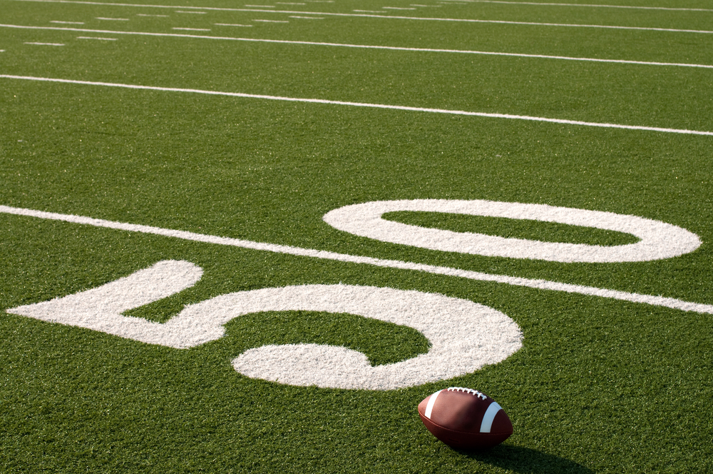 photograph of footbal next to the 50 yard line