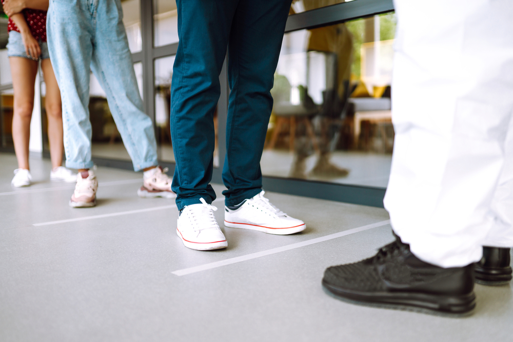 photograph of patients' feet standing in line waiting to get tested for COVID