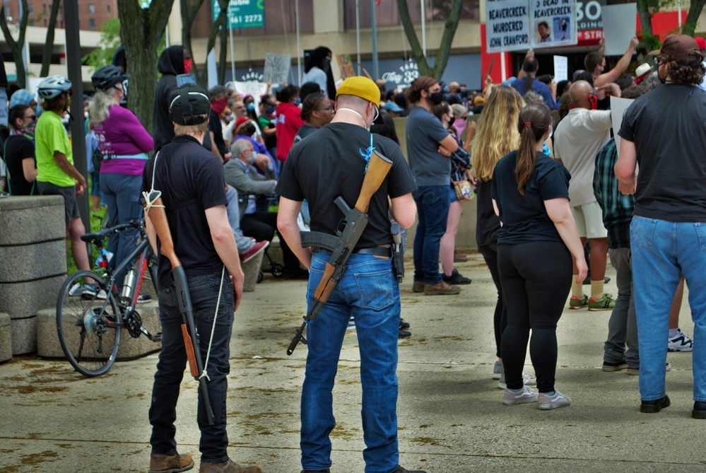 photograph of protesters carrying automatic rifles