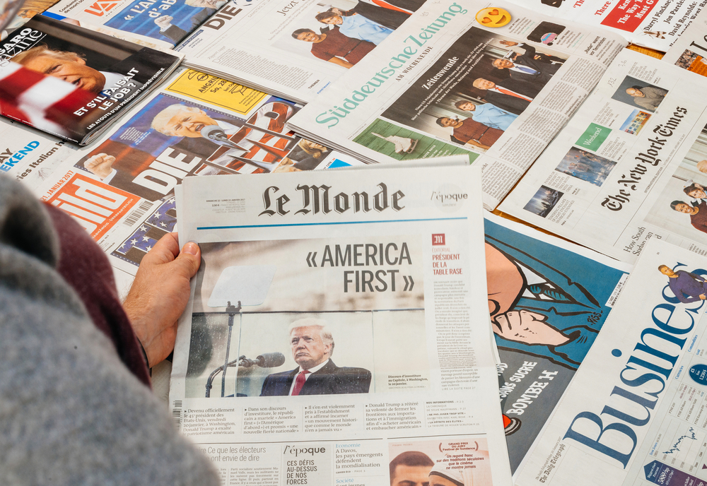 photograph of newspaper stand with various magazines with Trump on the cover