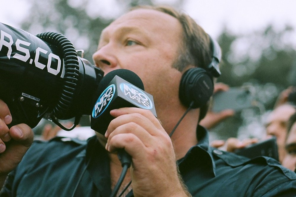 photograph of Alex Jones with megaphone reporting for InfoWars