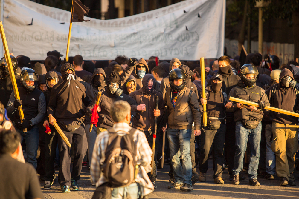 photograph of threatening protestor group with gas masks