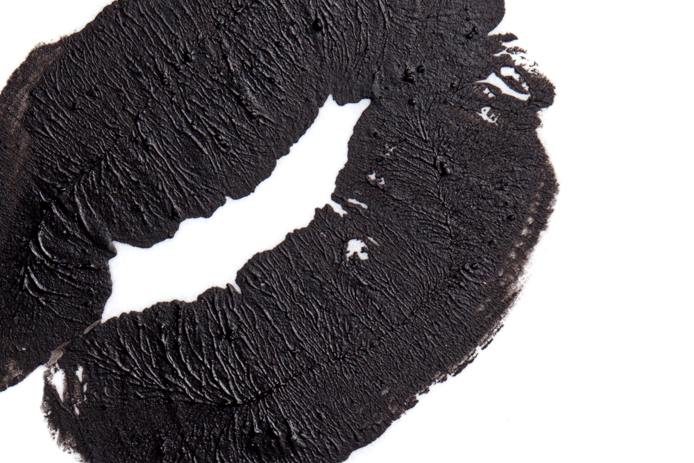 image of black lipstick kiss on white background