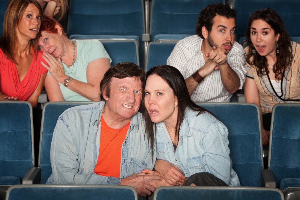 photograph of upset audiency members in a movie theater