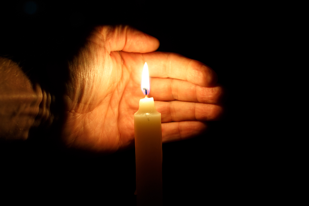 photograph of palm protecting candle at vigil