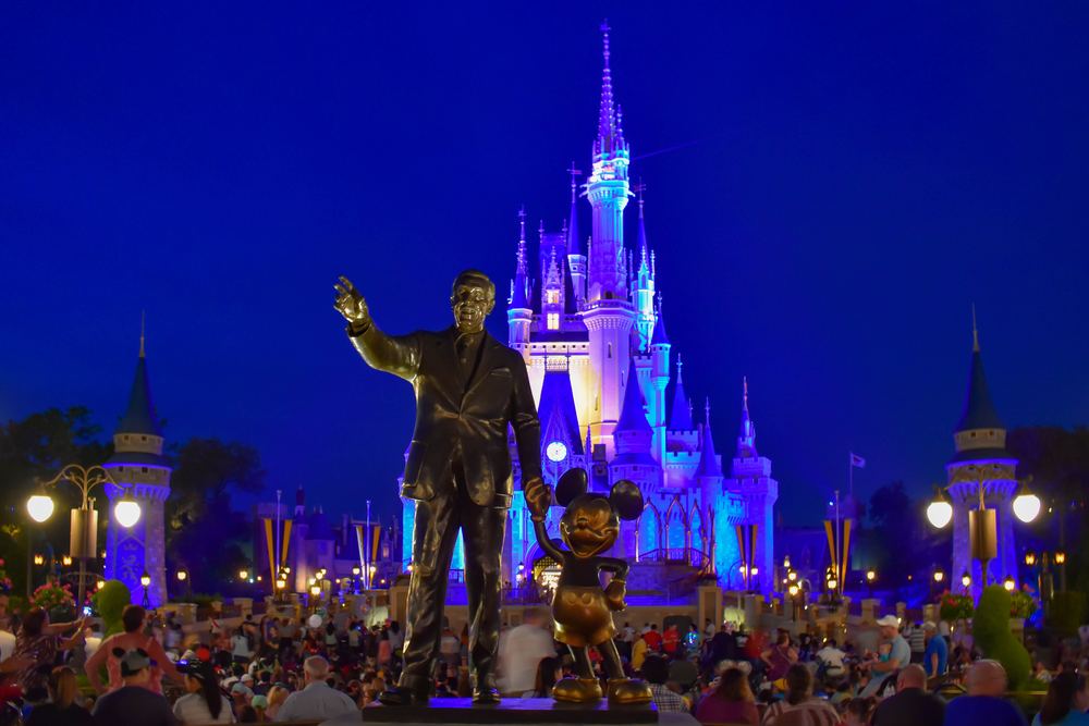 photograph of Walt Disney Statue with Disney Castle in background