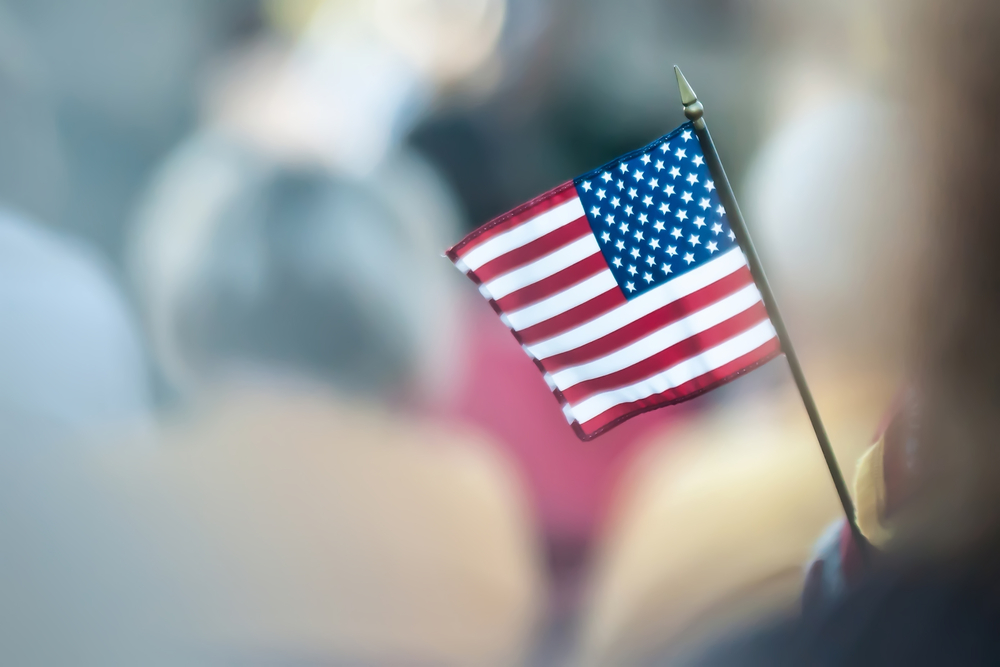 photograph of miniature US flag with blurred background