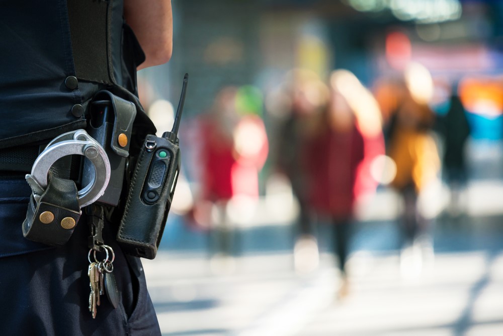 photograph of police officer with blurred civilians in the background