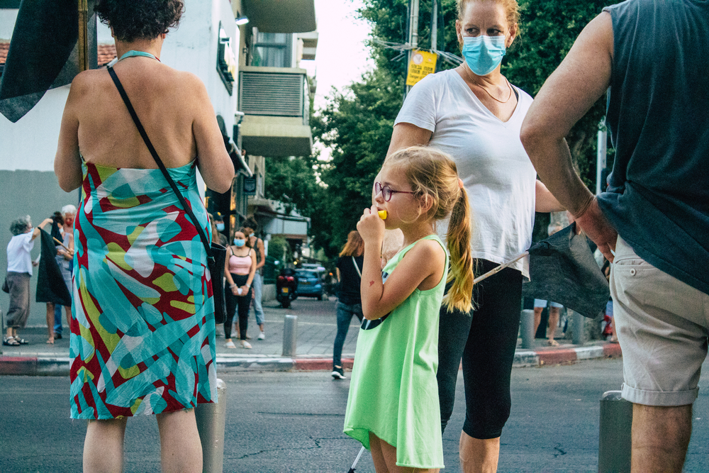 photograph of child among masked crowd