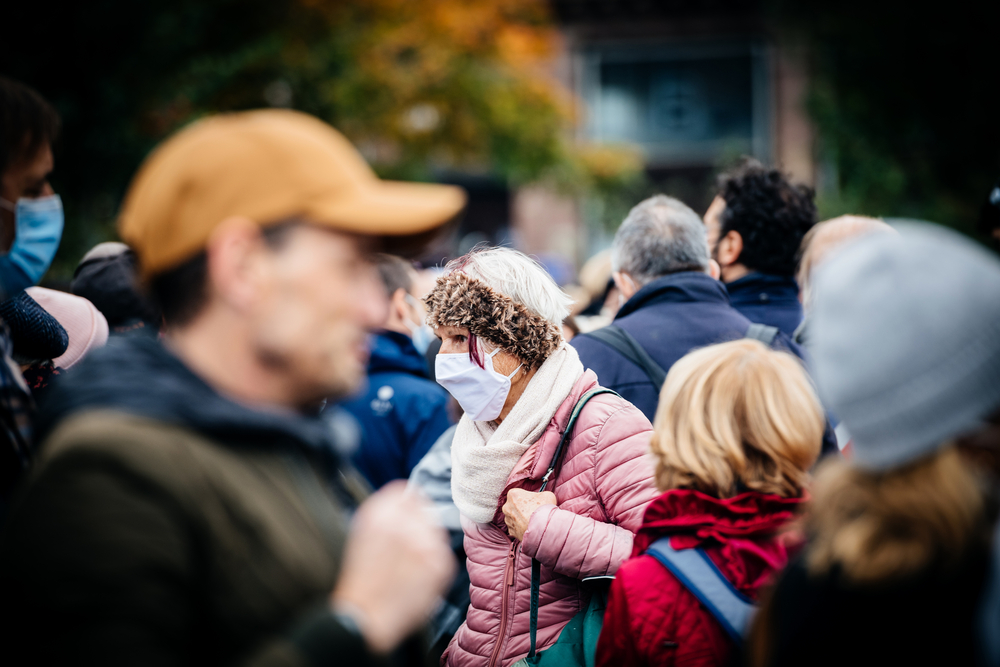 photograph of masked and unmasked people in a crowd