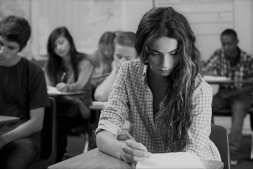 photograph of students studying at desks in classroom