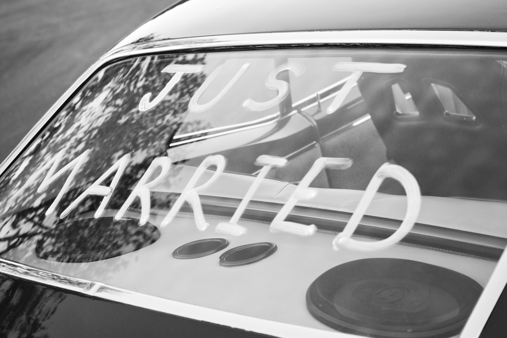 black and white photograph of "Just Married" in back window of vintage car