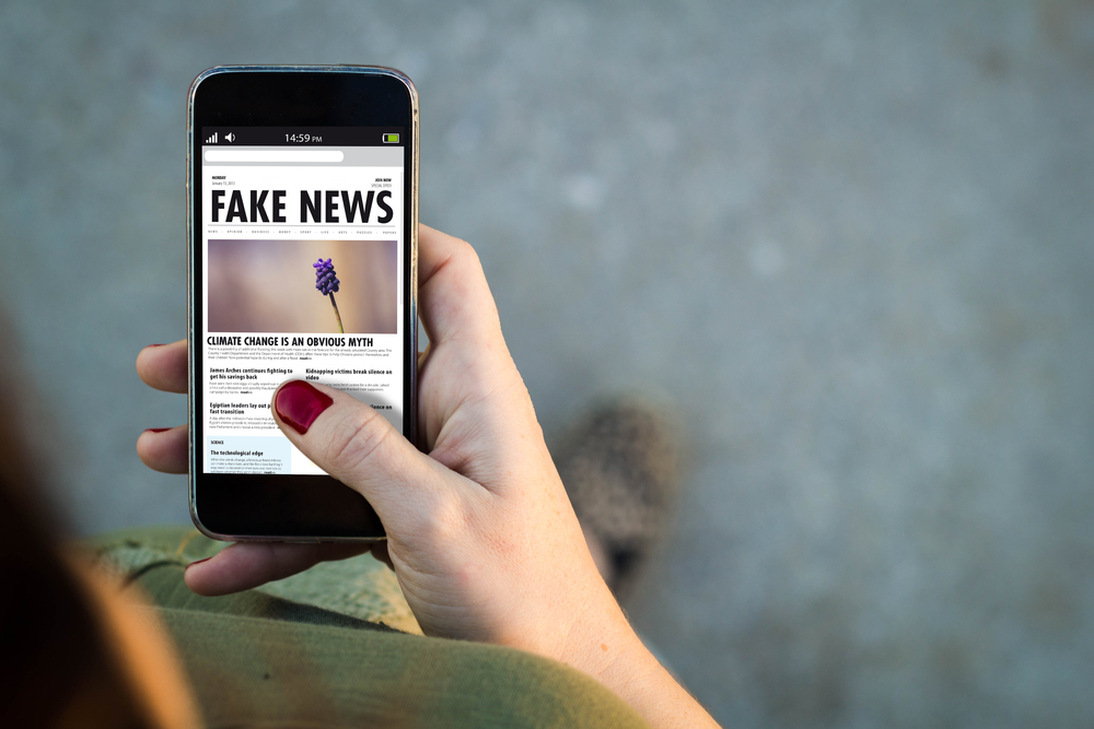 photograph of smartphone displaying 'Fake News' story