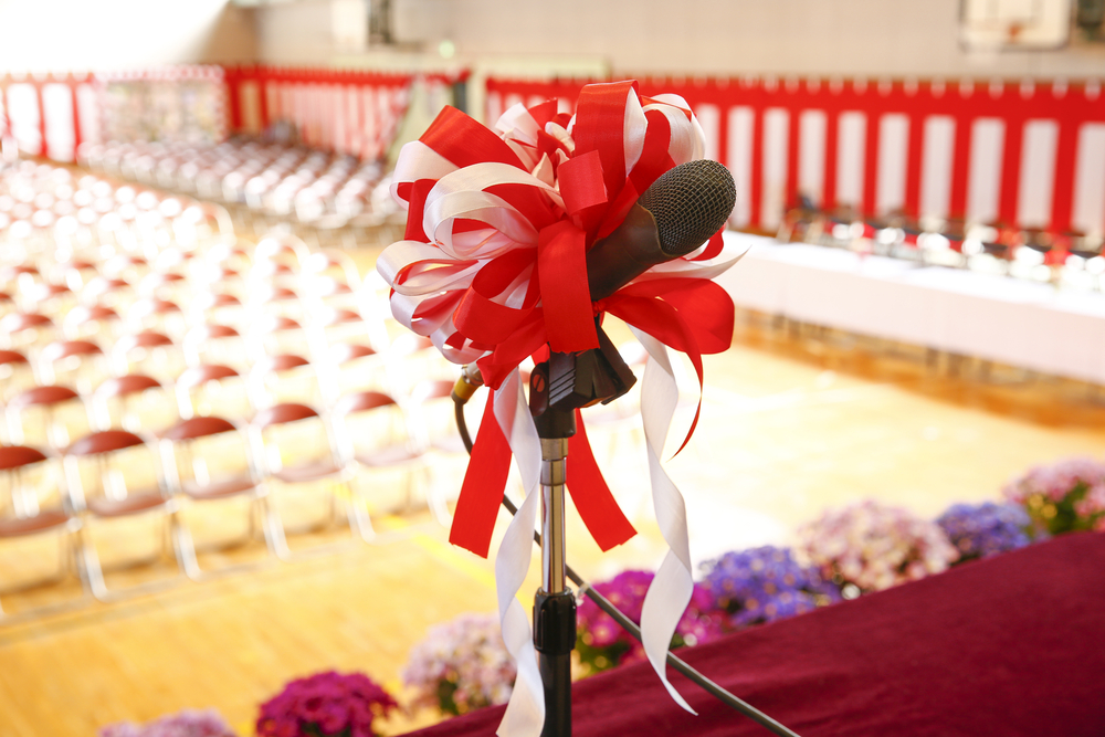 photograph of mic on graduation stage before empty chairs