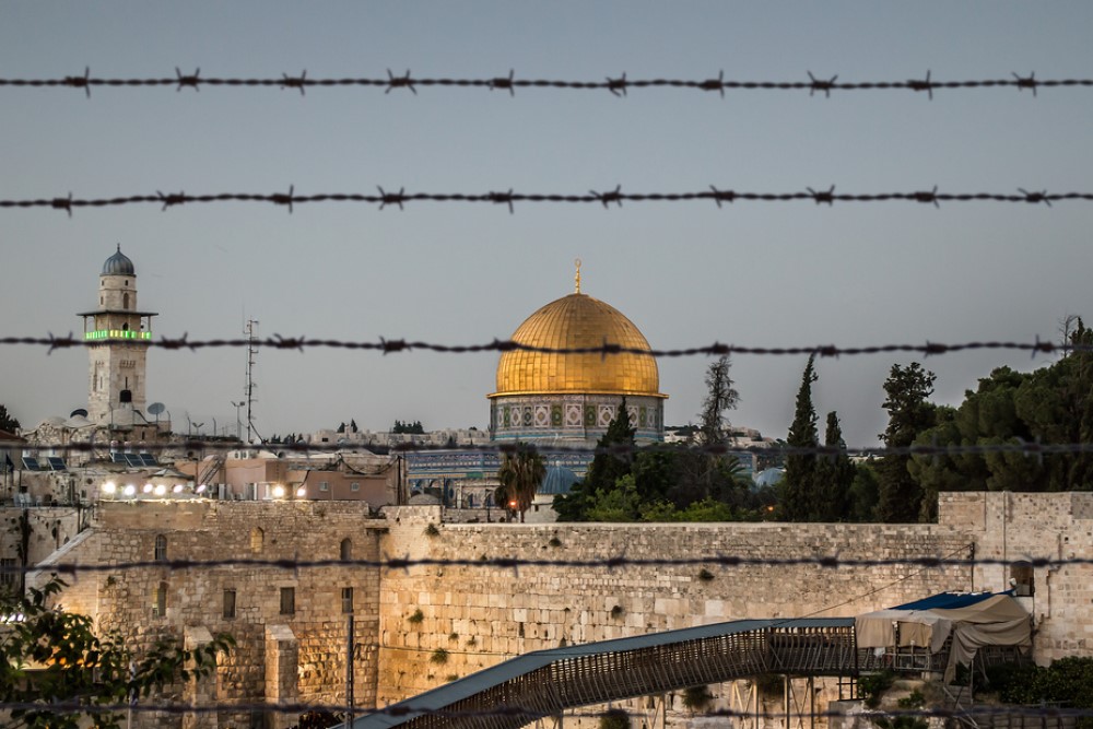 photograph of Jerusalem through barbed wire fence