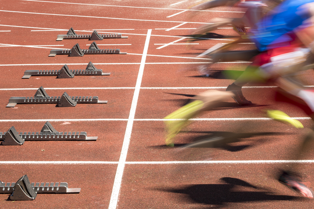 photograph of blurred sprinters leaving starting blocks