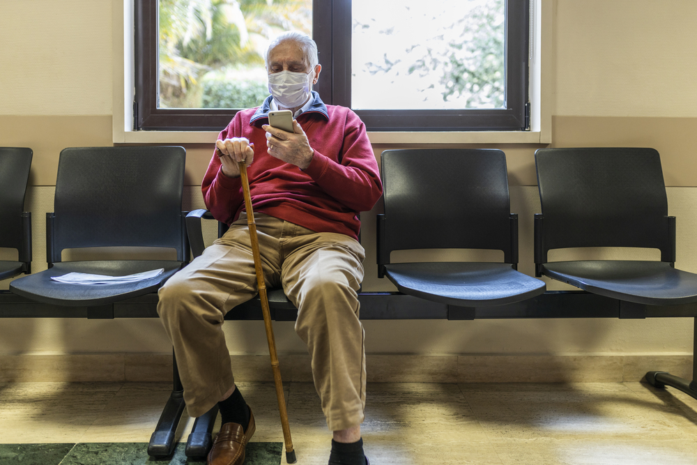 photograph of elderly man masked in waiting room