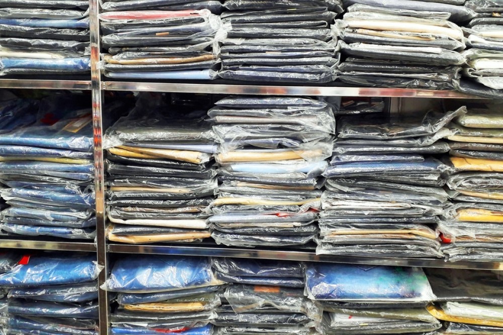 photograph of shelves of shirts in shrinkwrap