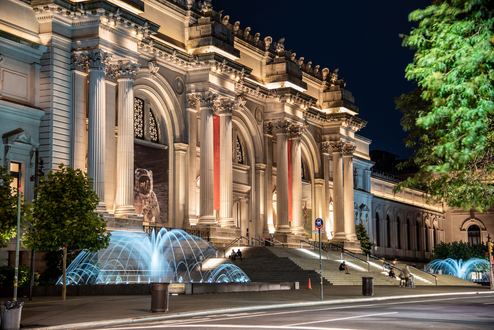 photograph of the lighted front of the Metropolitan museum of art at night