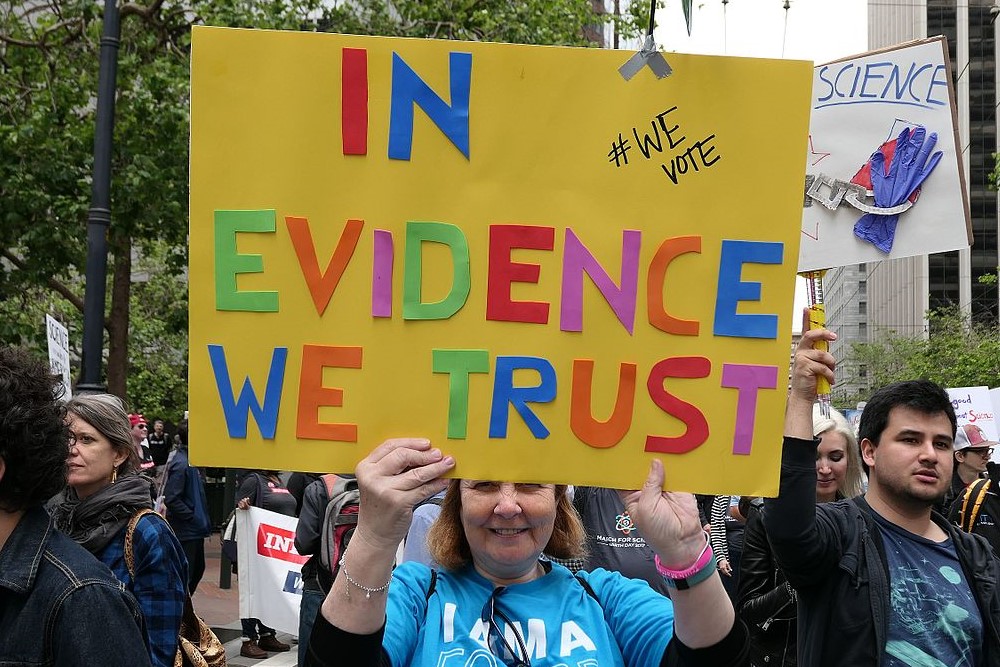 photograph of "In Evidence We Trust" protest sign