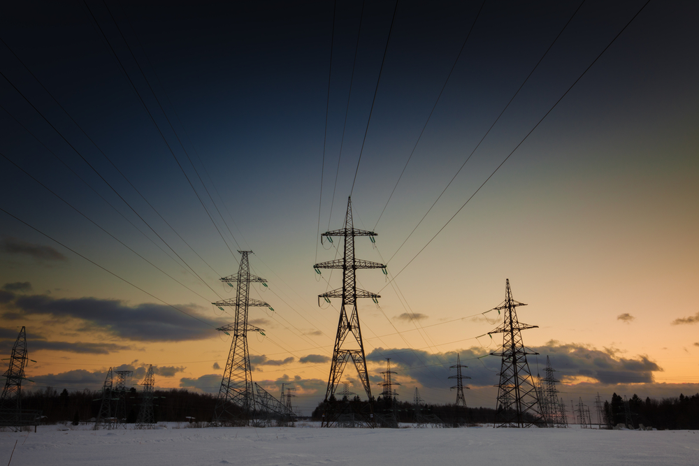 photograph of electric power pylons in winter landscape