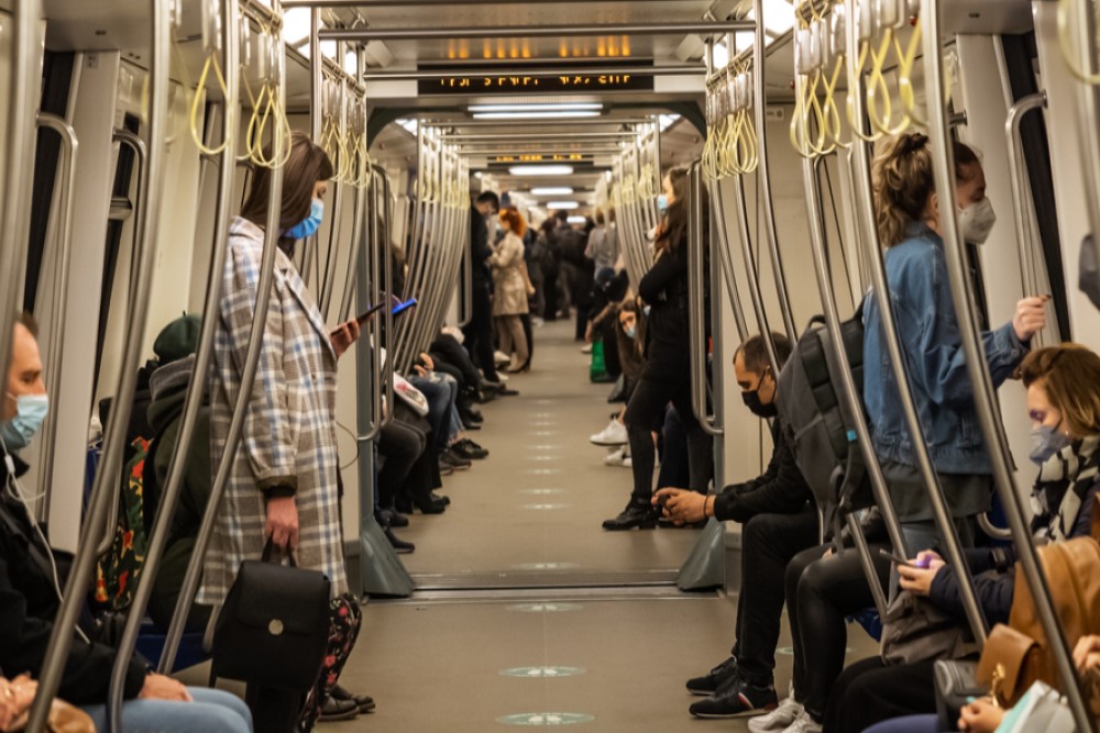 photograph of masked passengers on subway