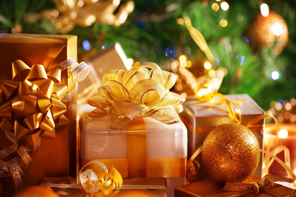 photograph of presents wrapped in gold before a Christmas tree