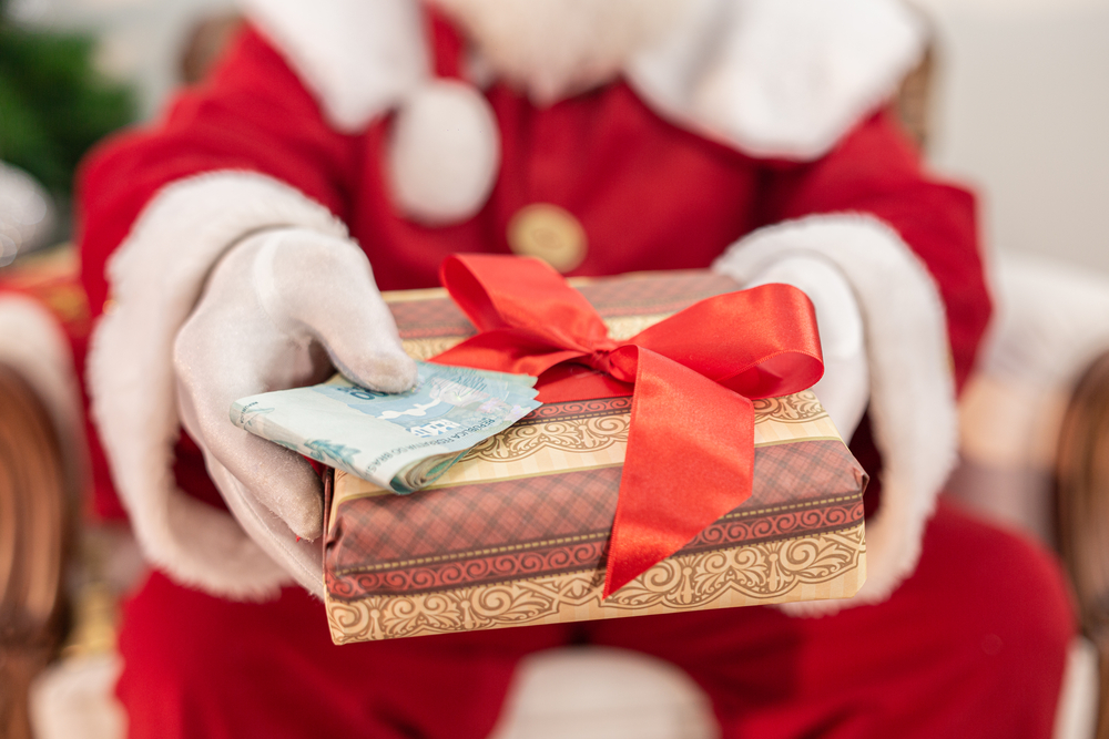 photograph of Santa Claus offering a gift and money