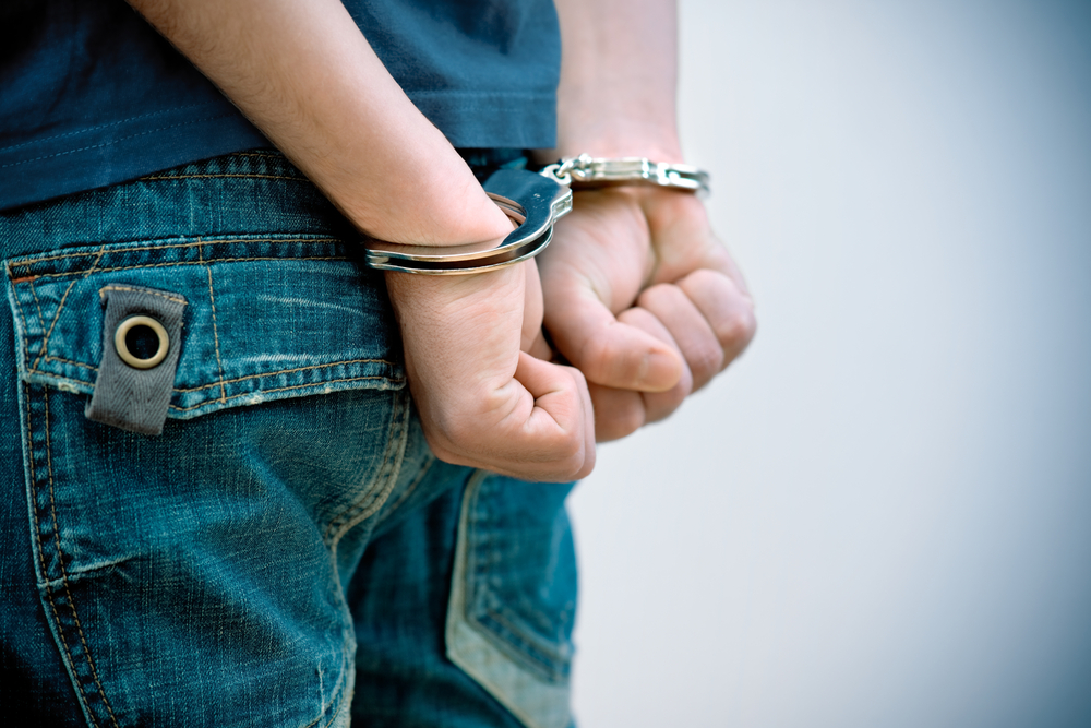 close-up photograph of youth in handcuffs