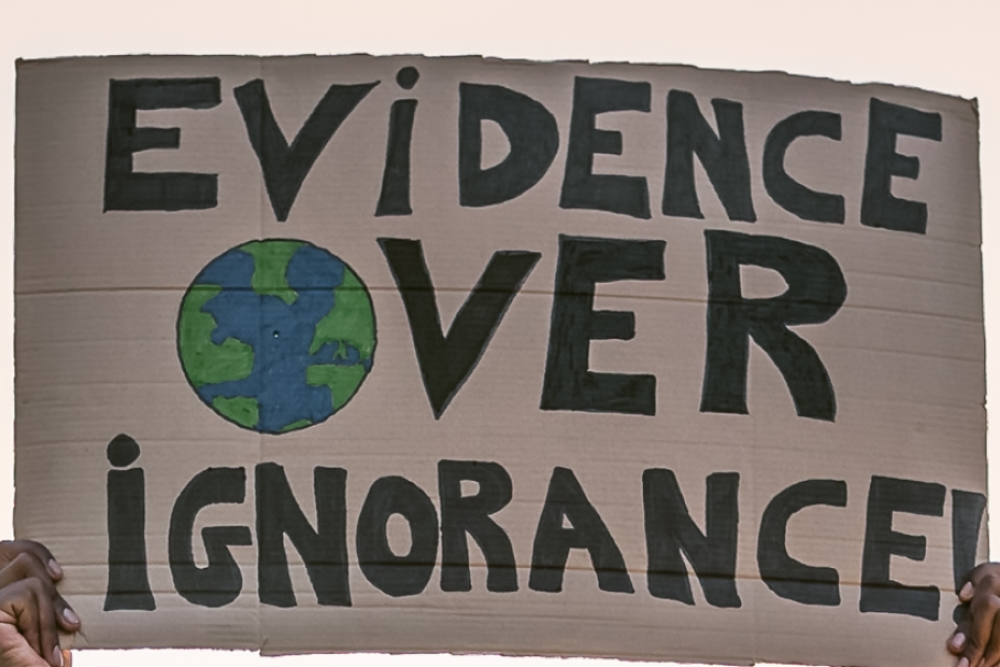photograph of "Evidence over Ignorance" protest sign