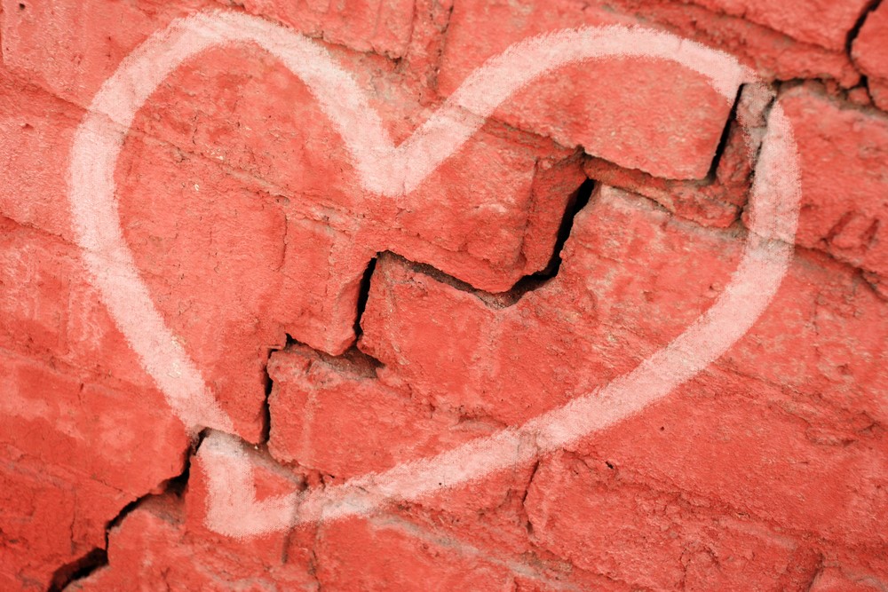 photograph of heart graffiti over crack in wall