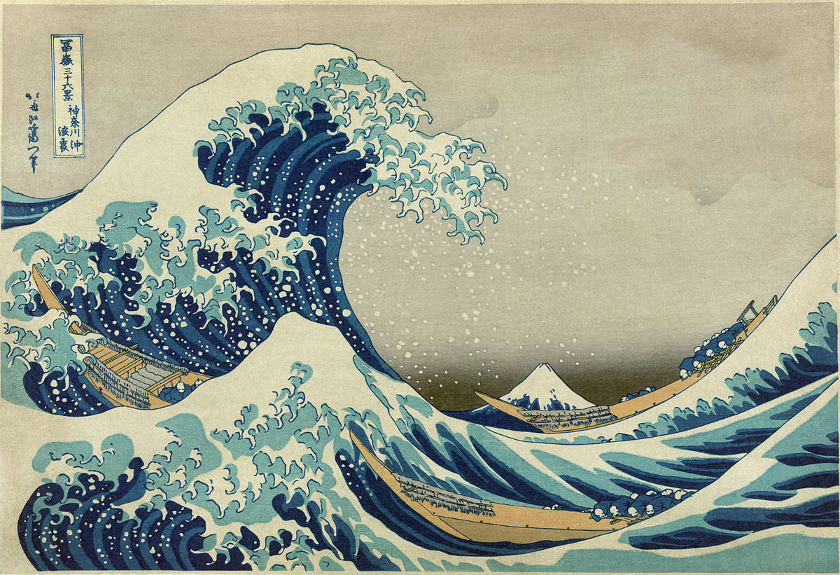 A woodblock print in color with a huge wave about to crash over two ships. Mount Fuji is in the background, but it is much smaller than any of the waves in the ocean.