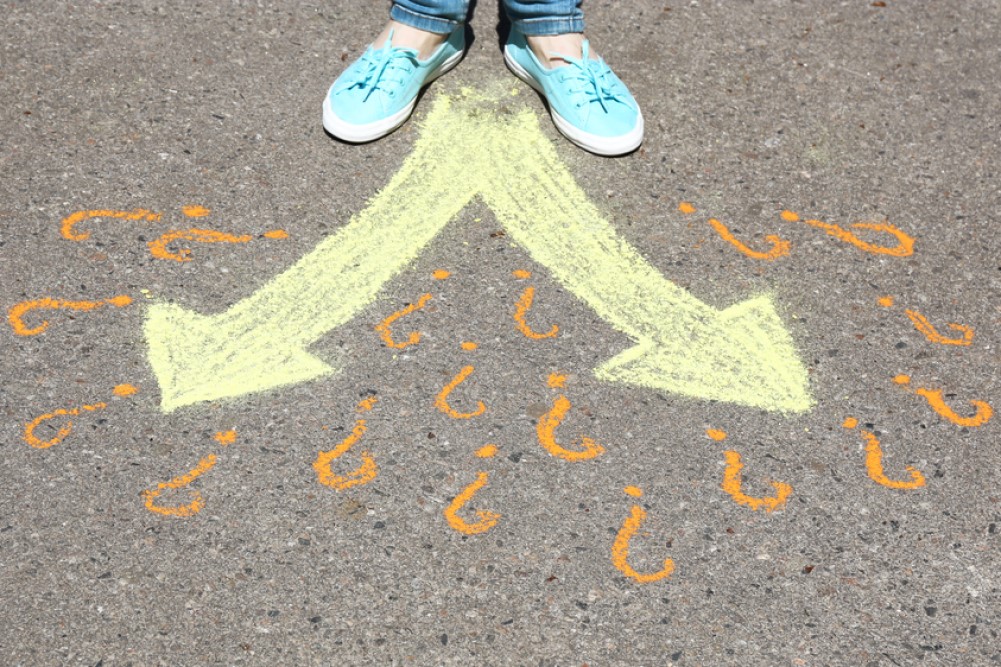 photograph of feet on asphalt before a branching decision tree