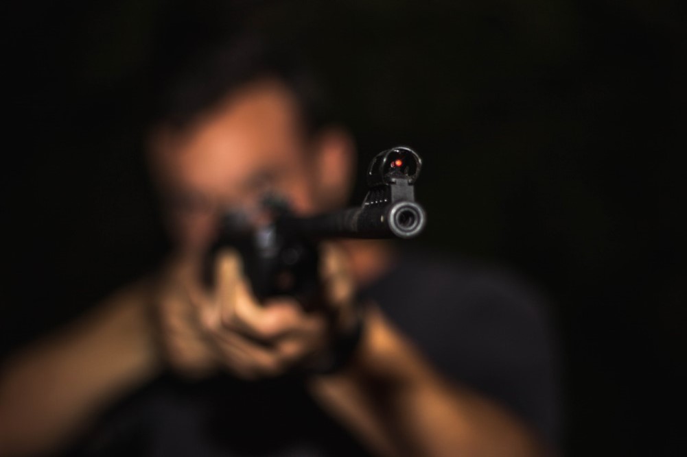 blurred photo of man aiming rifle