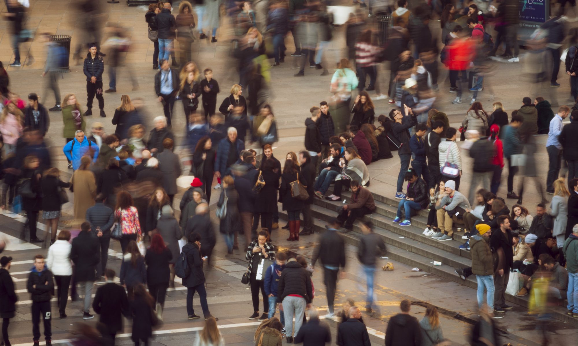 Birds-eye view of a crowd of people. Some people are in focus and others are blurred.