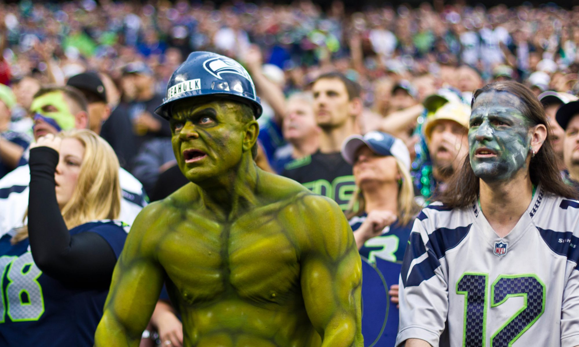Color photograph of a crowd of football fans, one of whom is dressed up like the Hulk